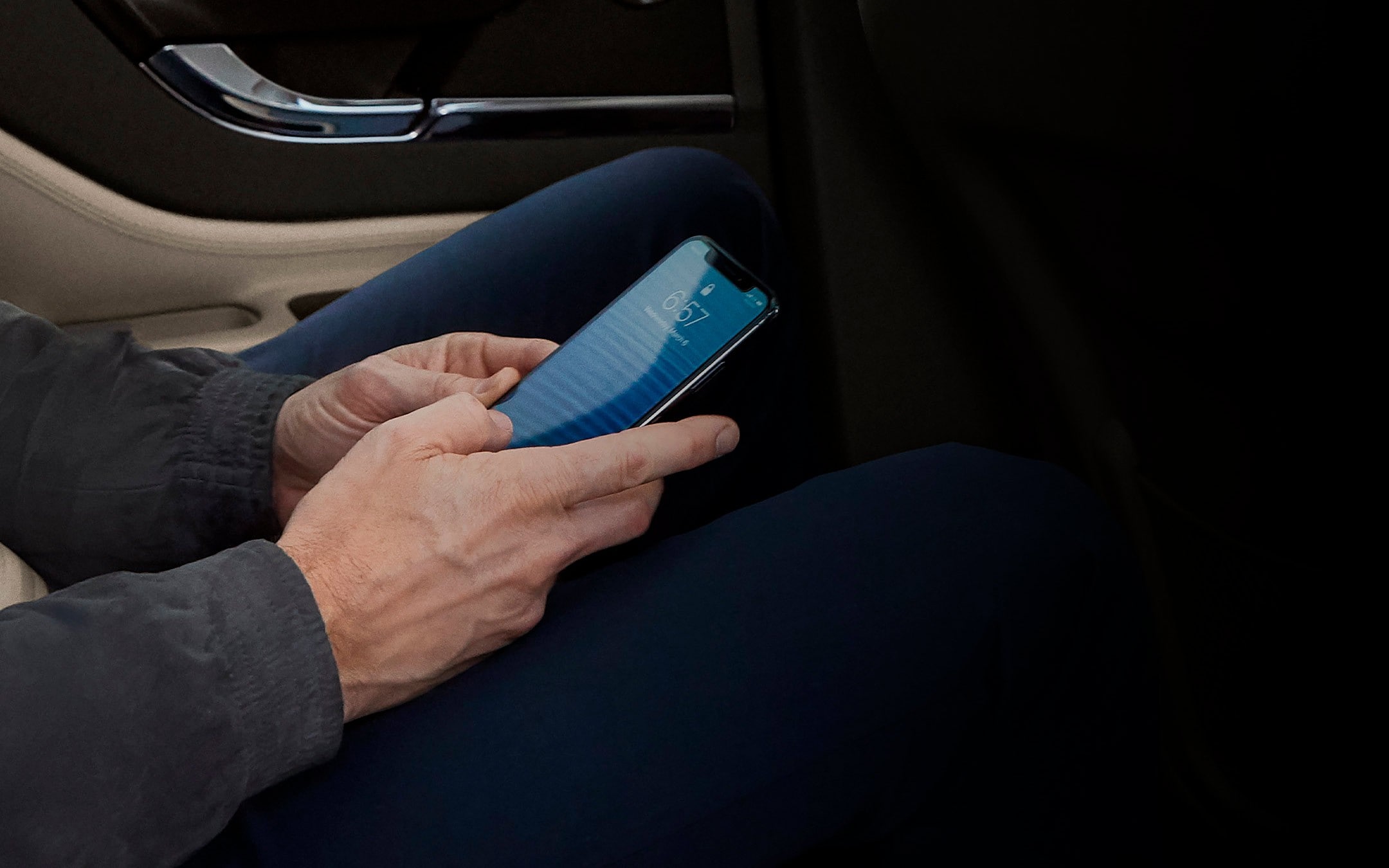 A person is shown using a mobile phone while using a 2025 Lincoln Corsair as a mobile Wi-Fi hotspot
